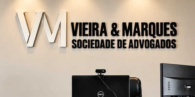 Letreiro com a marca Vieira & Marques na parede do escritório